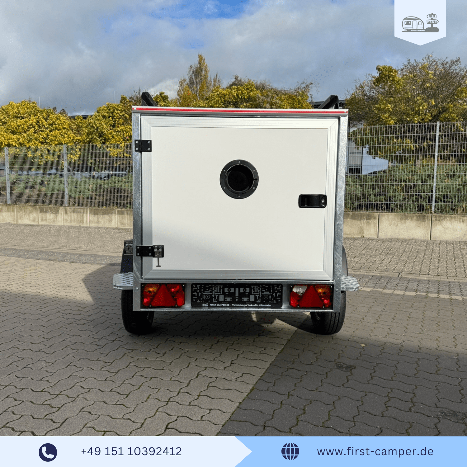 Heck des 750 kg Nano Campers mit rundem Bullaugen-Fenster und geöffneter Heckklappe.